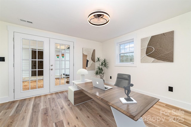 office with french doors, visible vents, baseboards, and wood finished floors