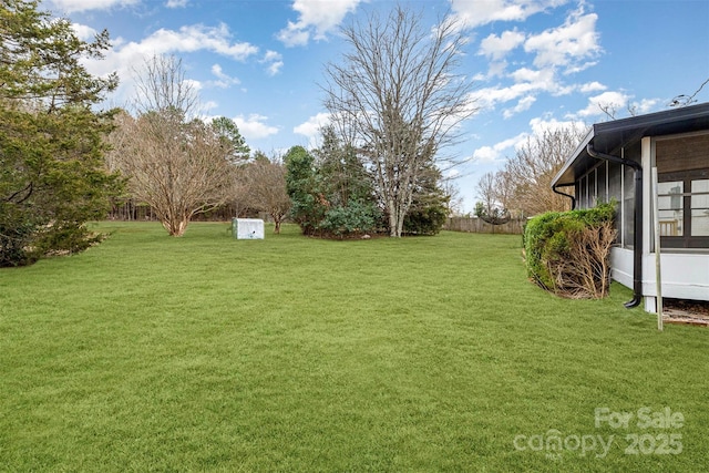 view of yard featuring fence and a sunroom