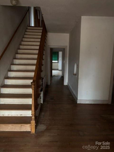 stairway with wood finished floors and baseboards