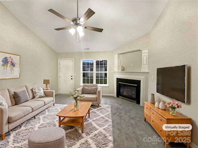 carpeted living room featuring vaulted ceiling, ceiling fan, a glass covered fireplace, and visible vents