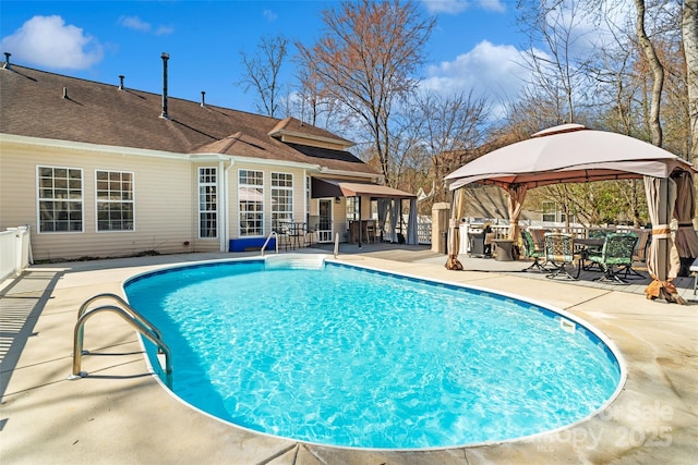 pool with a patio area, fence, and a gazebo