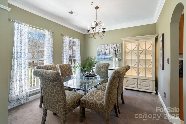 dining room featuring carpet, arched walkways, and a wealth of natural light