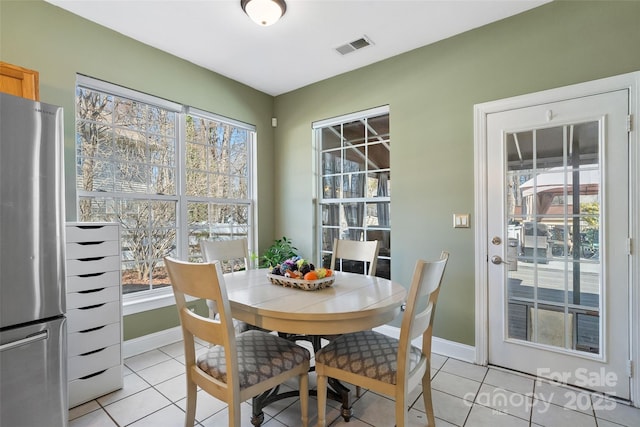 dining area with light tile patterned floors, visible vents, and baseboards