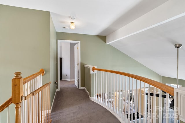 hallway with baseboards, vaulted ceiling, carpet flooring, and an upstairs landing