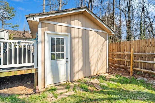 view of outbuilding featuring fence and an outbuilding