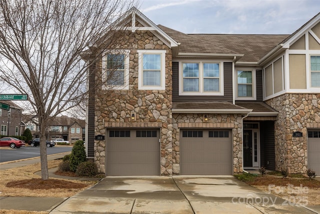 view of front of house with a garage, driveway, and a shingled roof