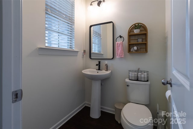 bathroom with toilet, baseboards, and a sink