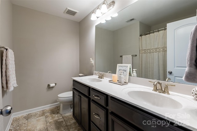 bathroom featuring double vanity, a sink, and visible vents