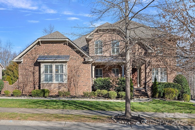 view of front facade featuring a front yard, stone siding, and brick siding