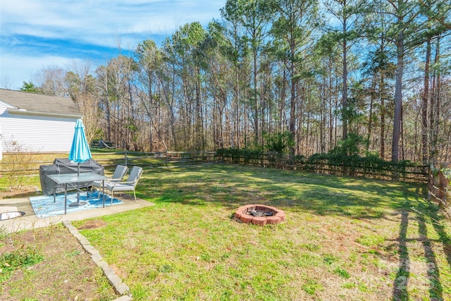 view of yard featuring an outdoor fire pit, a fenced backyard, and a patio