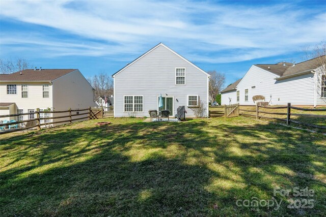 back of property with a fenced backyard and a yard