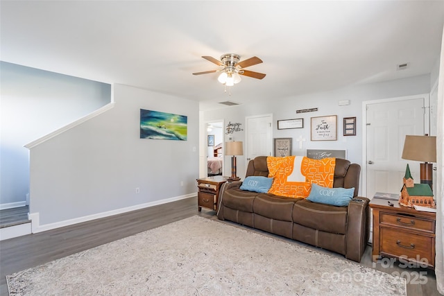 living area featuring baseboards, visible vents, a ceiling fan, and wood finished floors