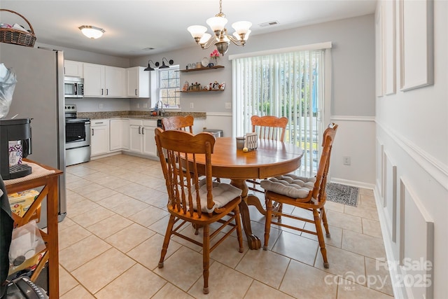 dining space featuring visible vents, a notable chandelier, and light tile patterned flooring