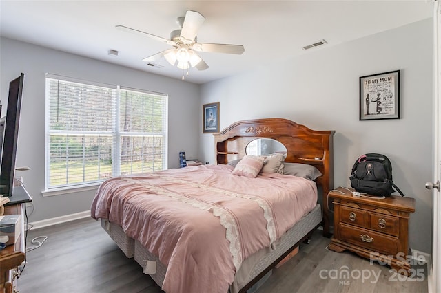 bedroom featuring visible vents, baseboards, and wood finished floors