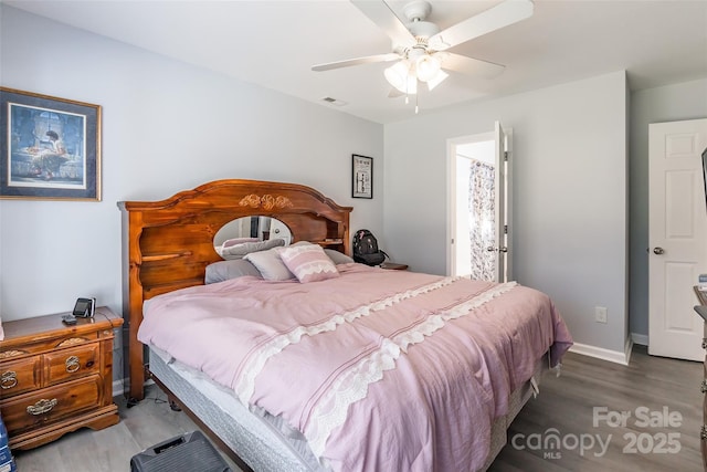 bedroom with wood finished floors, a ceiling fan, and baseboards