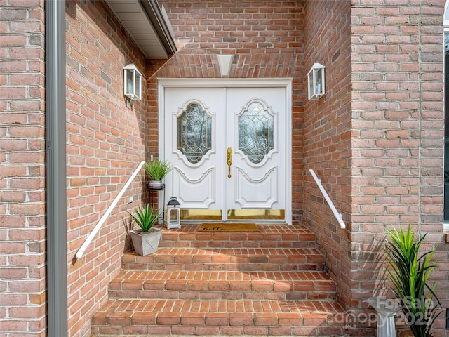 property entrance with french doors and brick siding