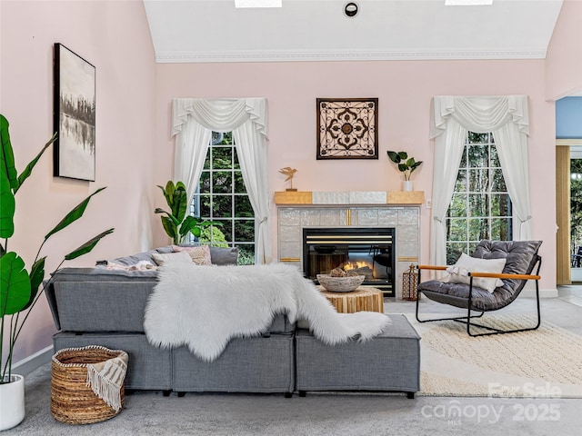 living room with baseboards, ornamental molding, and a tile fireplace