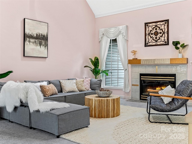 living room featuring ornamental molding, vaulted ceiling, and a tile fireplace