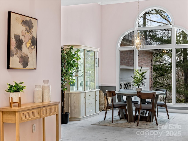 dining room featuring light carpet and a chandelier