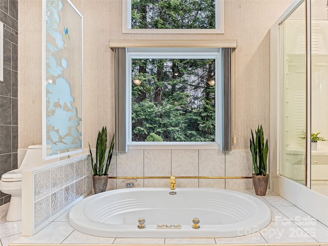 bathroom featuring a whirlpool tub and toilet