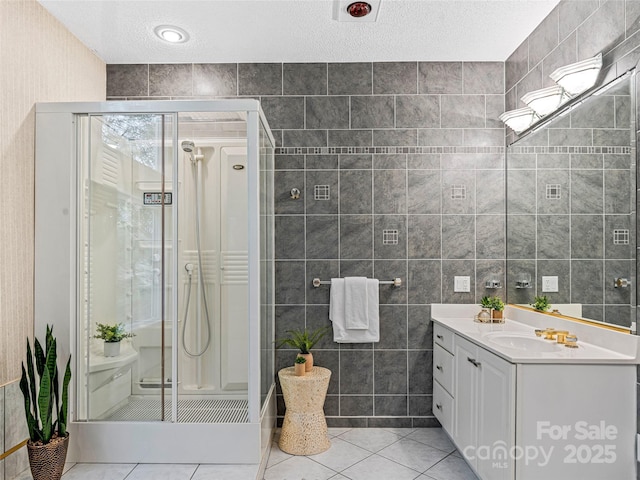 bathroom with tile patterned flooring, tile walls, and a shower stall