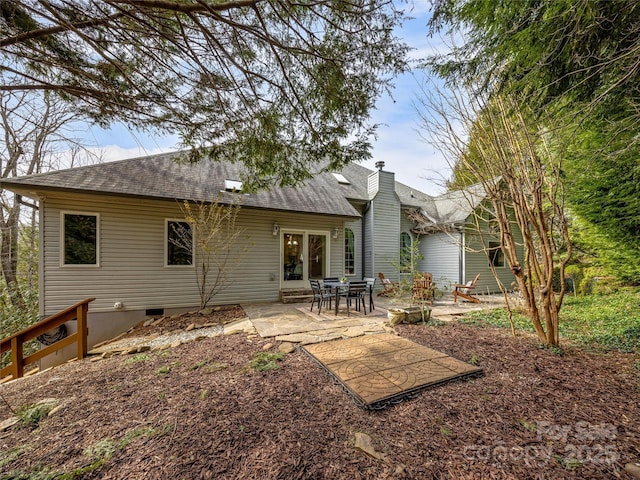 rear view of house with a shingled roof, crawl space, a patio, and a chimney