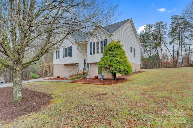 view of front of house with stairs, a front lawn, and brick siding