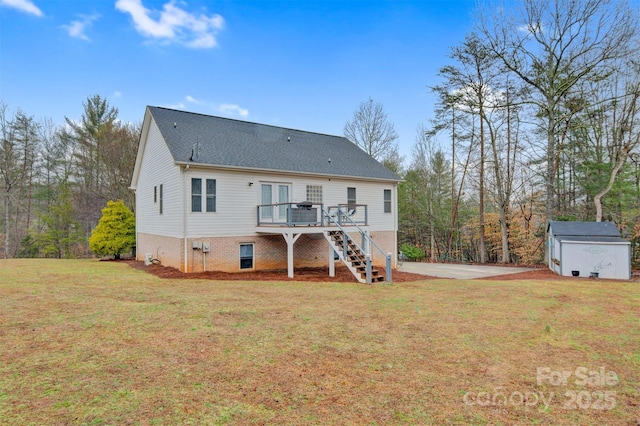 rear view of property featuring a wooden deck, stairway, an outbuilding, a yard, and a shed