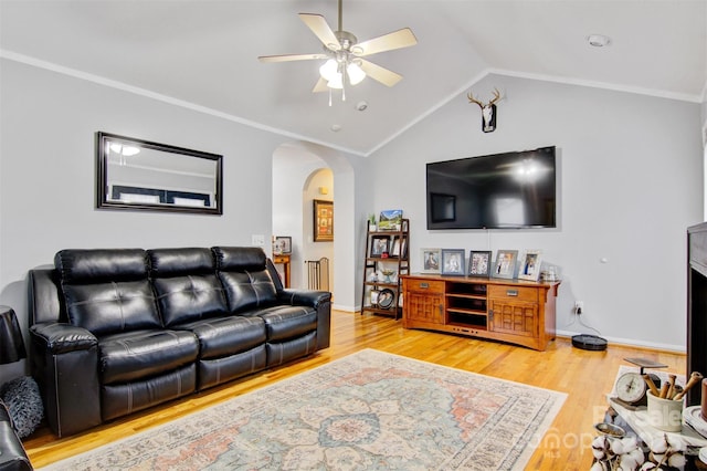 living area with arched walkways, ceiling fan, vaulted ceiling, and wood finished floors