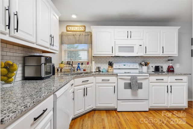 kitchen featuring light wood-style floors, white appliances, white cabinetry, and a sink