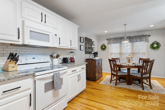 kitchen with pendant lighting, light wood finished floors, decorative backsplash, white cabinetry, and white appliances