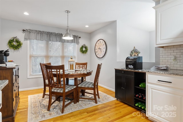 dining room with light wood-style floors, recessed lighting, and baseboards