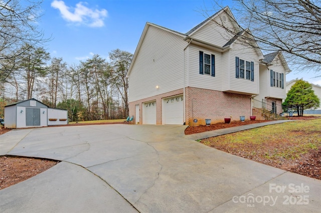 view of property exterior featuring an outbuilding, driveway, brick siding, and a garage