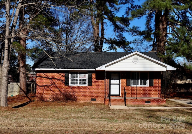 view of front of house with a shingled roof, crawl space, fence, a front lawn, and brick siding