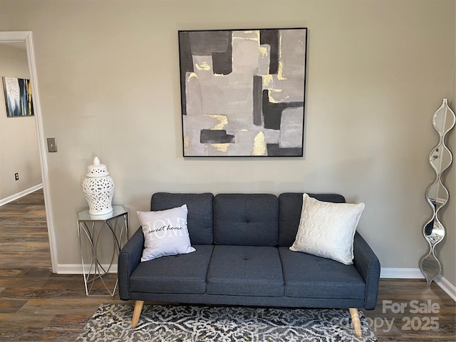 living area featuring baseboards and wood finished floors