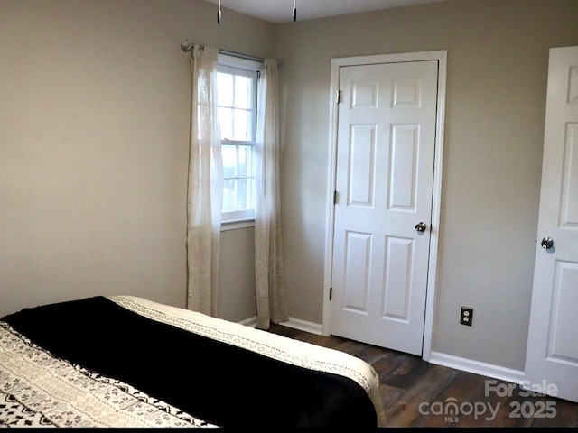 bedroom featuring dark wood-style floors and baseboards