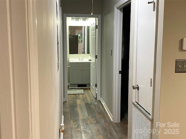 hallway featuring dark wood finished floors and a sink