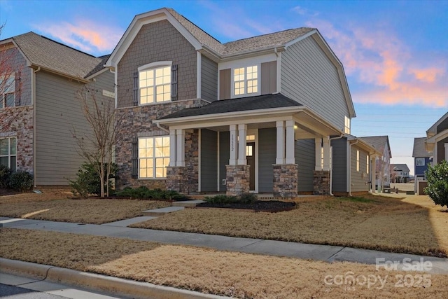 view of front of home with stone siding and a porch