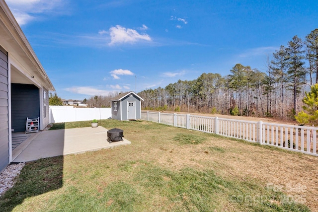 view of yard with a fire pit, a patio, a fenced backyard, an outdoor structure, and a shed