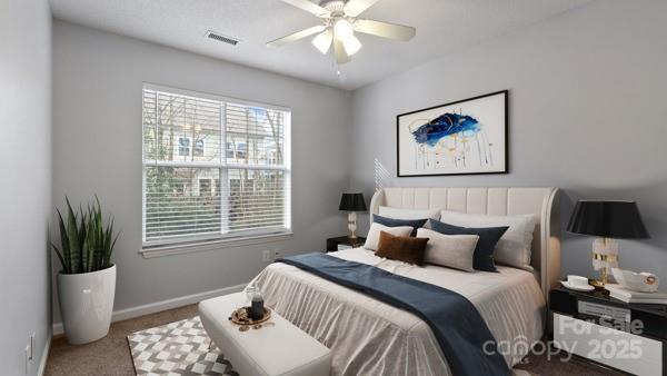 bedroom with a ceiling fan, carpet flooring, visible vents, and baseboards