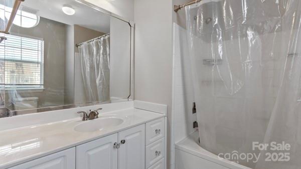 bathroom featuring vanity and shower / bathtub combination with curtain