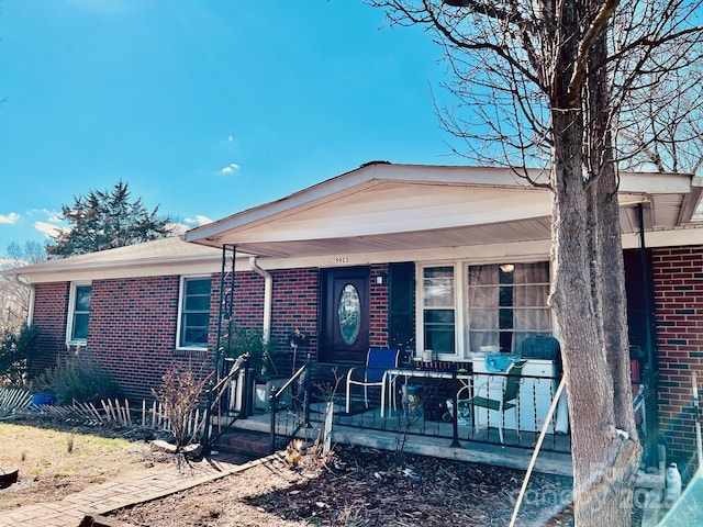 view of front facade with covered porch and brick siding