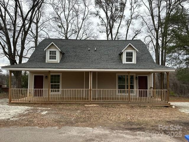 view of front of home featuring covered porch and a shingled roof