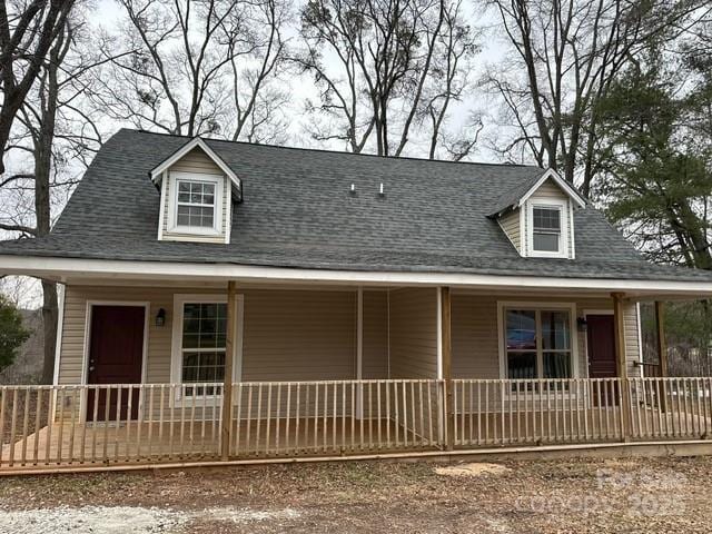 view of front of home featuring a shingled roof and covered porch