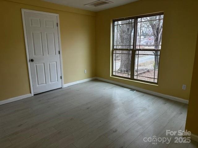 unfurnished room featuring light wood-type flooring and baseboards