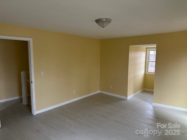 empty room featuring light wood-style floors and baseboards