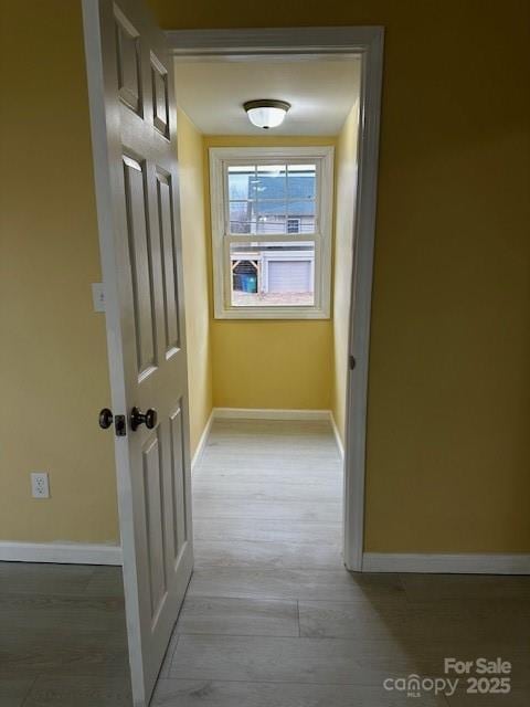 hallway with light wood-style flooring and baseboards