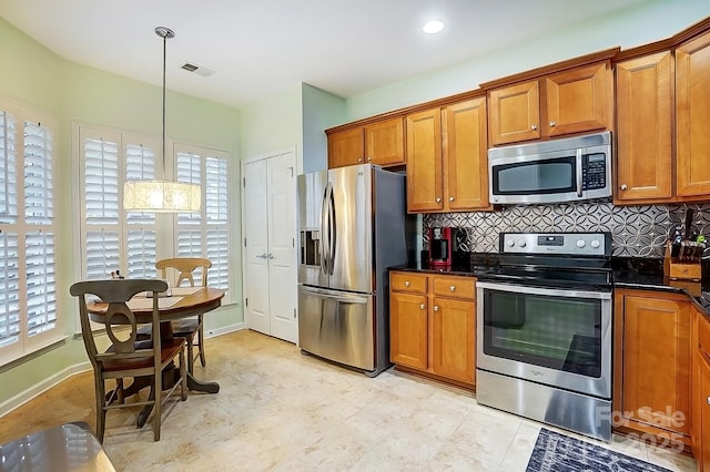 kitchen featuring dark countertops, brown cabinetry, visible vents, and stainless steel appliances