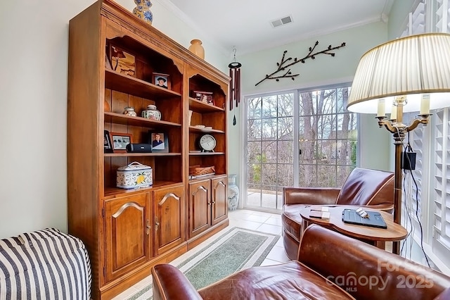 sitting room featuring light tile patterned floors, visible vents, and crown molding