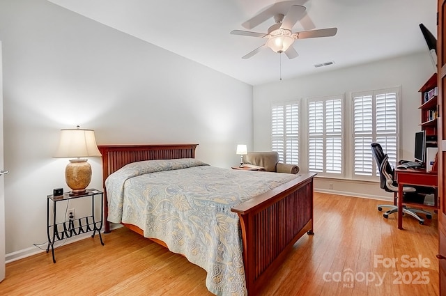 bedroom with light wood-style flooring, visible vents, and baseboards